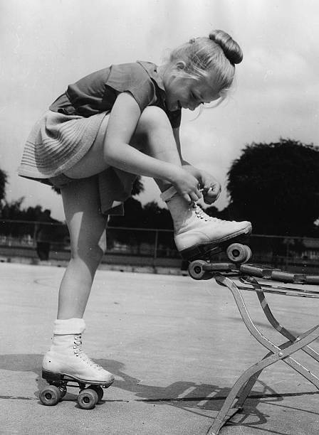 Girl from the Berlin Roller Skating Club laces up roller skates 1952 1953 Photo