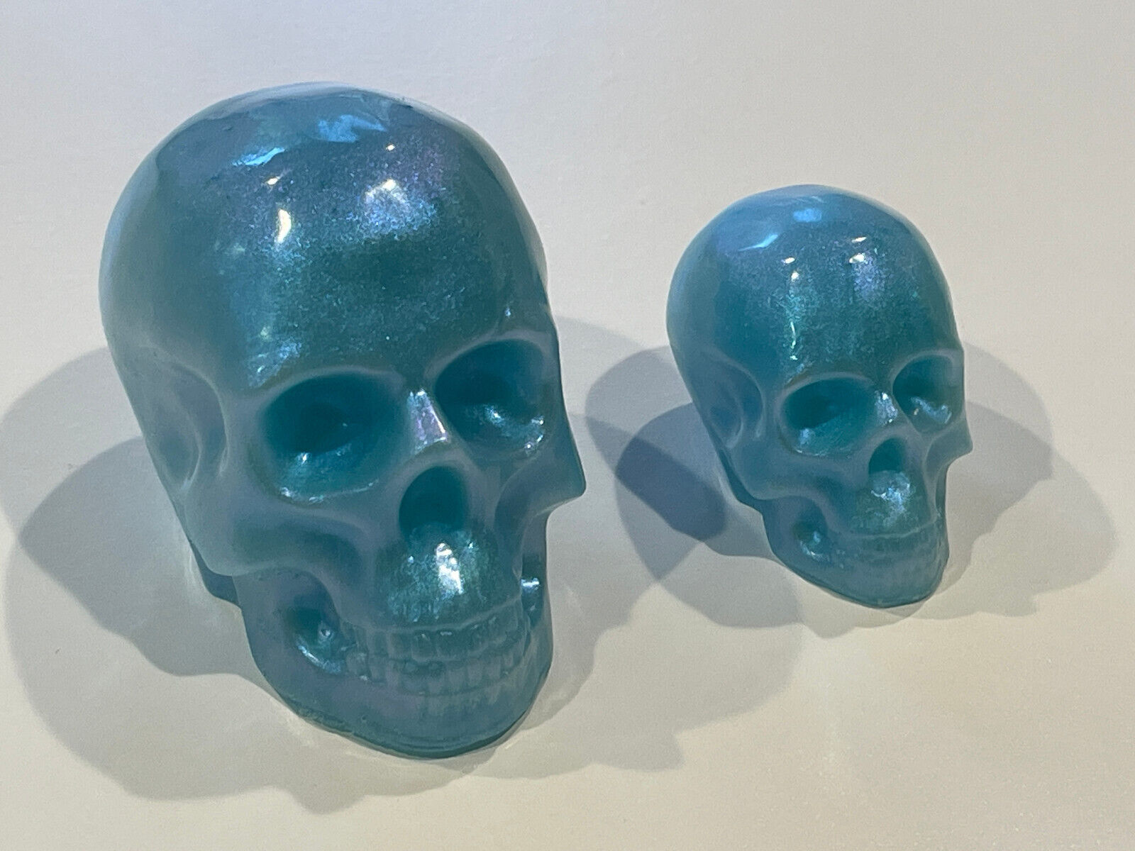 Matched pair Icy Blue Sparkle Solid Resin Skulls.  