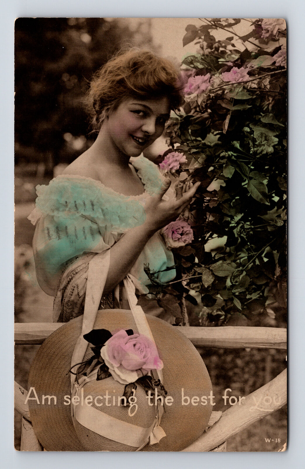 c1918 RPPC hand Colored Portrait of Young Woman Picking Roses Hat Postcard