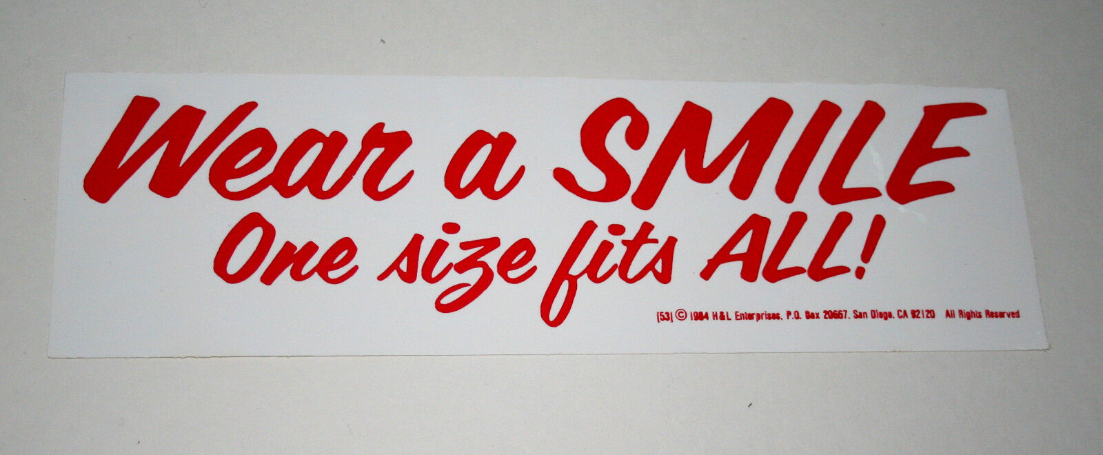 Vtg Campy Slogan Wear A Smile 1 Size Fits All Funny Bumper Sticker New NOS 1984