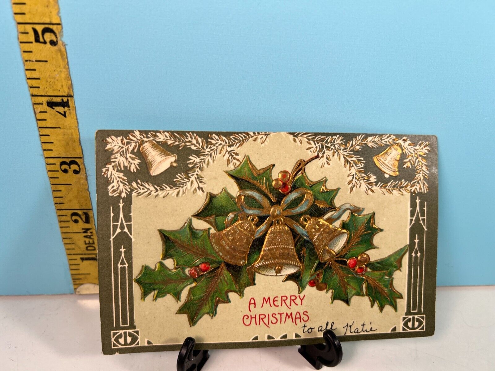1907 A Merry Christmas embossed Gold Bells cascaded in Green Holly Postcard.
