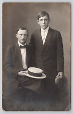RPPC Two Young Men In Studio Holding Hats c1910 Real Photo Postcard picture