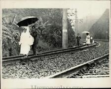 1971 Press Photo Man holds train of his bride's dress on railroad track, Brazil picture
