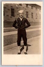 eStampsNet - RPPC WWII Sailor in Uniform Standing in Front of Barracks Postcard picture