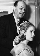 Famed hat stylist John Fredericks fitting one of creations to bea- 1956 Photo picture